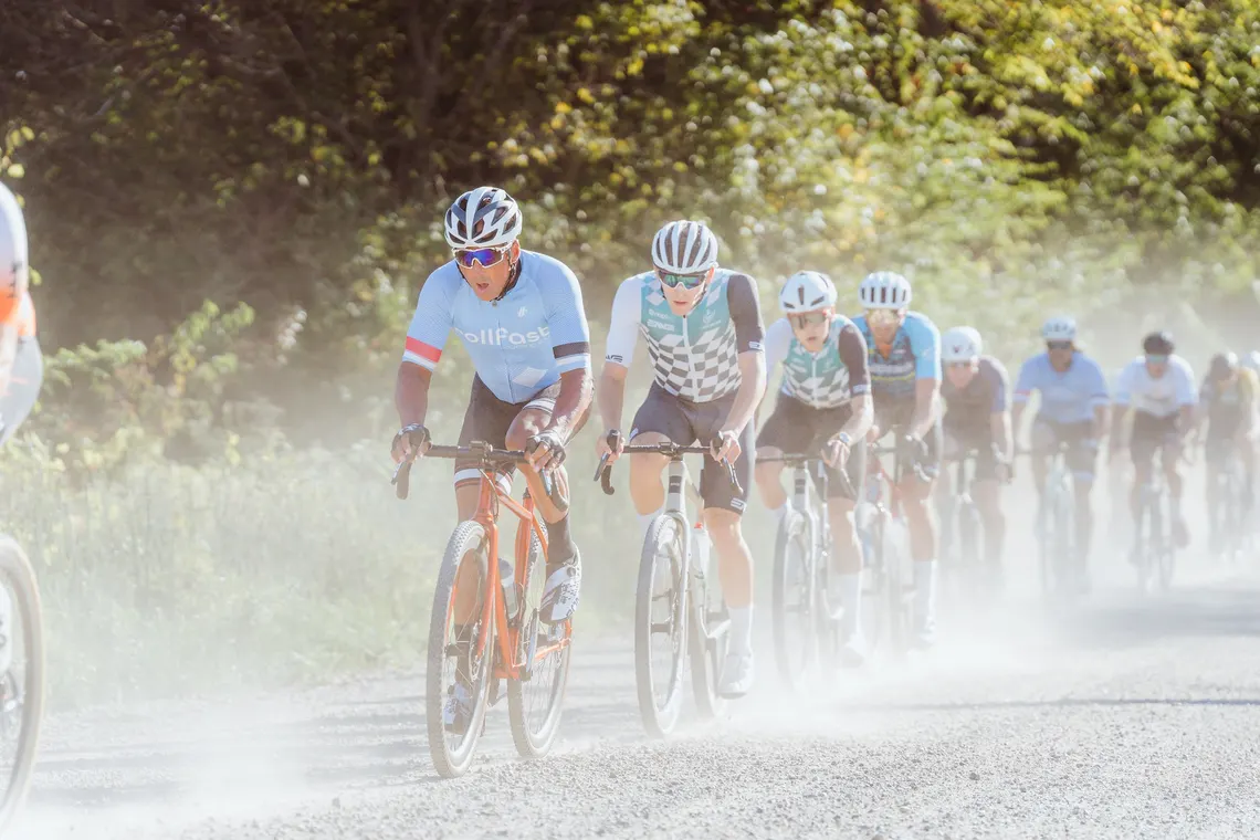 Riders in a dust cloud on a gravel road